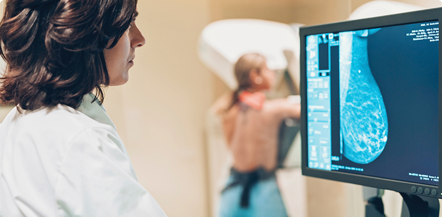 Una doctora visualiza en una pantalla los resultados en tiempo real de una paciente a la que está realizando una mamografía